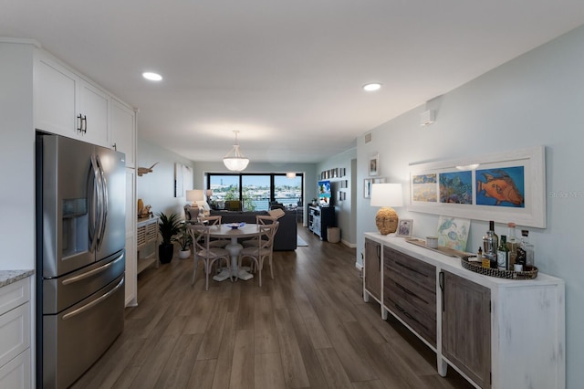 kitchen with open floor plan, recessed lighting, stainless steel refrigerator with ice dispenser, dark wood-style floors, and white cabinets