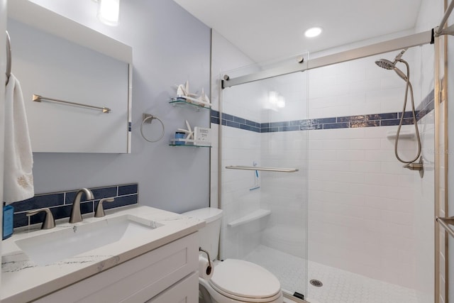 bathroom featuring vanity, toilet, and a stall shower