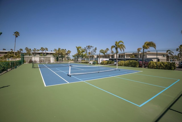 view of tennis court with community basketball court and fence