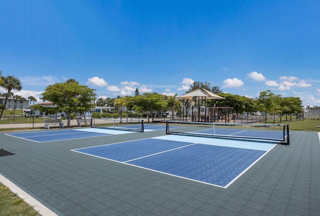 view of sport court featuring playground community and fence