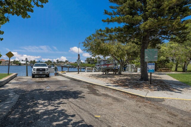 view of street featuring curbs, a water view, and sidewalks