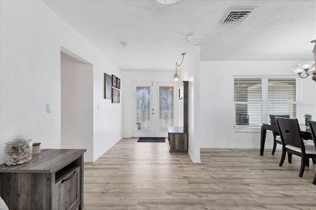 entryway with visible vents, french doors, an inviting chandelier, light wood finished floors, and baseboards