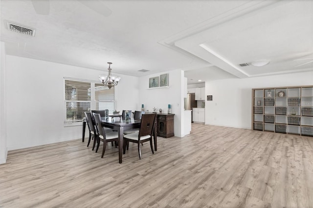 dining area featuring an inviting chandelier, baseboards, visible vents, and light wood finished floors