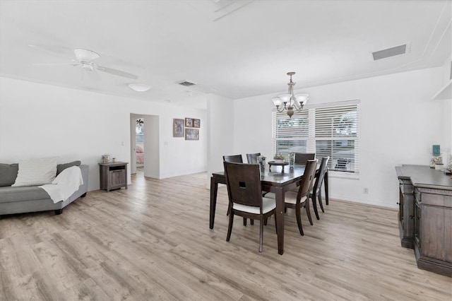 dining space featuring ceiling fan with notable chandelier, light wood-style floors, and visible vents