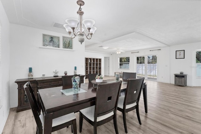 dining space featuring ceiling fan with notable chandelier, baseboards, and light wood-style floors