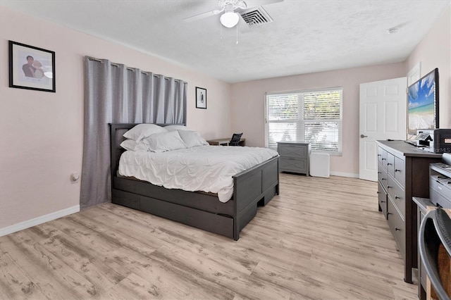 bedroom with visible vents, light wood-style flooring, baseboards, and ceiling fan