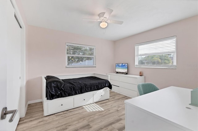 bedroom with light wood-style flooring, baseboards, and ceiling fan