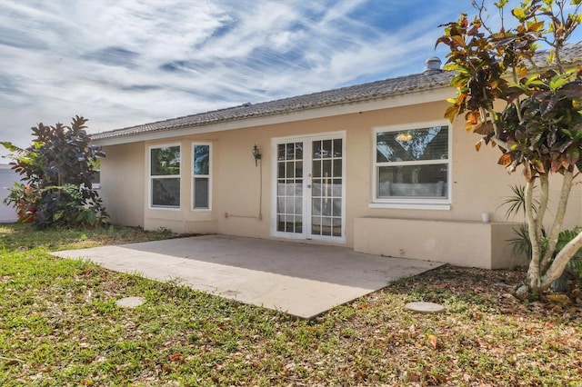 back of house with french doors, stucco siding, and a patio area