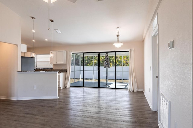 4659 Alligator Dr, Venice, FL 34293 - kitchen with dark countertops, visible vents, pendant lighting, dark wood-style floors, and fridge