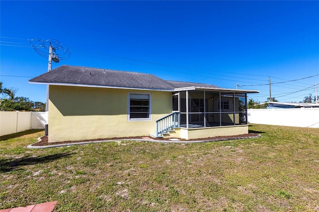4659 Alligator Dr, Venice, FL 34293 - back of property with a fenced backyard, a sunroom, a shingled roof, stucco siding, and a lawn