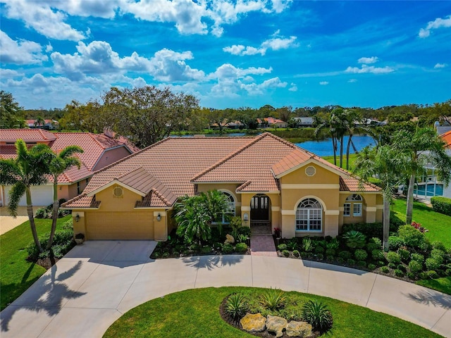 mediterranean / spanish house with stucco siding, concrete driveway, a front lawn, a garage, and a tile roof