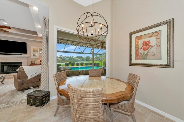 dining area featuring stone finish floor, recessed lighting, a fireplace, a sunroom, and baseboards