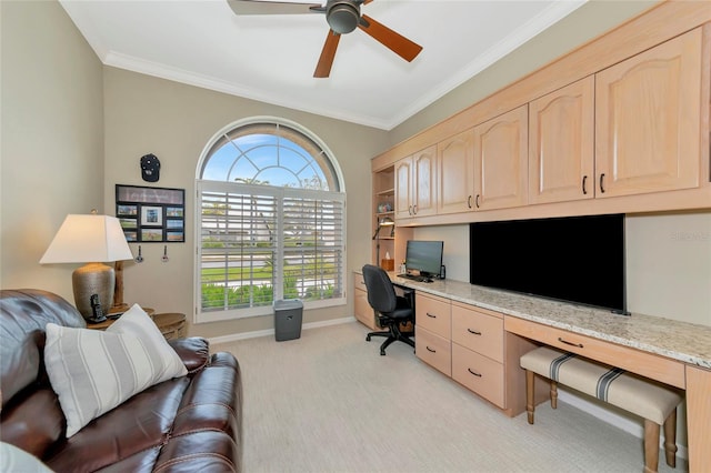 office space with baseboards, ceiling fan, ornamental molding, light carpet, and built in study area