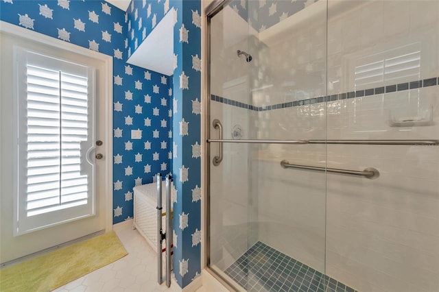 bathroom with wallpapered walls and a stall shower