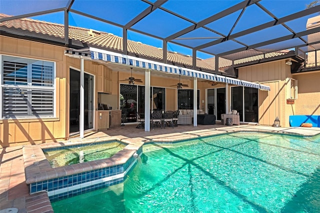 view of swimming pool featuring a ceiling fan, glass enclosure, a patio area, and a pool with connected hot tub