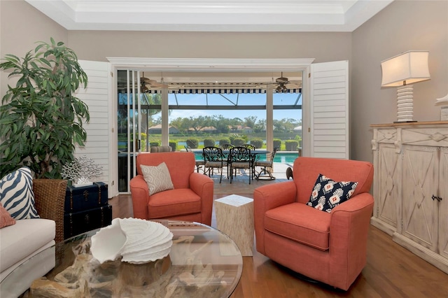 living room with ornamental molding, a sunroom, and wood finished floors