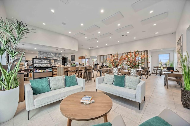 living area with a high ceiling, light tile patterned floors, and recessed lighting