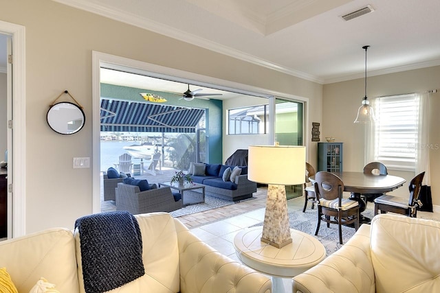 living area featuring crown molding, plenty of natural light, a ceiling fan, and visible vents