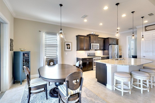 kitchen with stainless steel appliances, dark brown cabinetry, visible vents, and crown molding