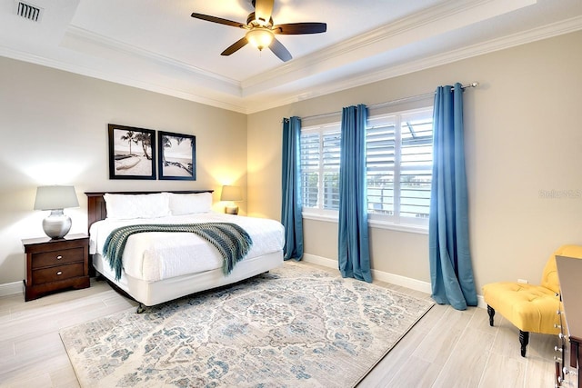 bedroom with visible vents, a raised ceiling, baseboards, and ornamental molding