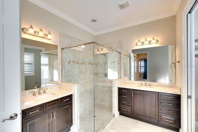 full bathroom featuring crown molding, a stall shower, visible vents, and a sink