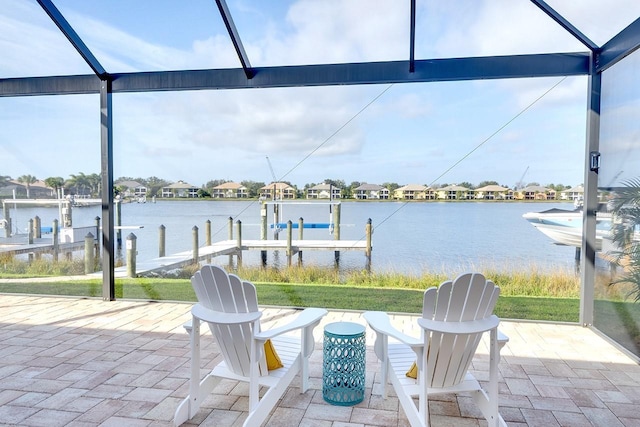 view of patio featuring boat lift, glass enclosure, a dock, and a water view