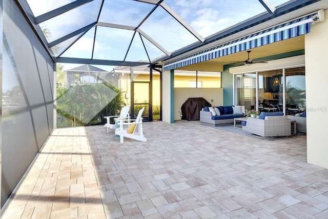 view of patio / terrace featuring glass enclosure, ceiling fan, and outdoor lounge area