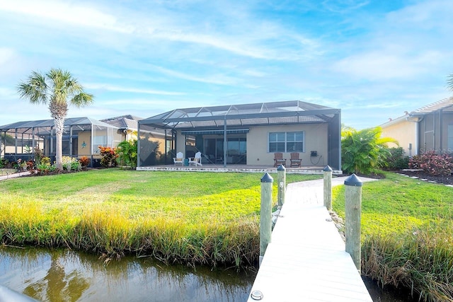 back of property with a water view, a lawn, and a lanai