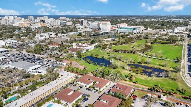 bird's eye view featuring a city view, view of golf course, and a water view