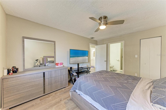 bedroom featuring connected bathroom, a textured ceiling, light wood-style floors, and a ceiling fan