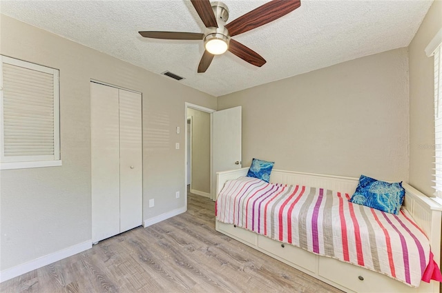 unfurnished bedroom with visible vents, baseboards, wood finished floors, a textured ceiling, and a ceiling fan