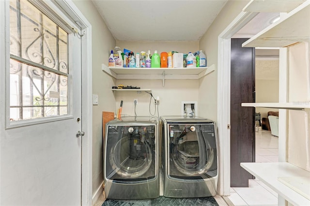 laundry area with tile patterned flooring, laundry area, and washing machine and clothes dryer