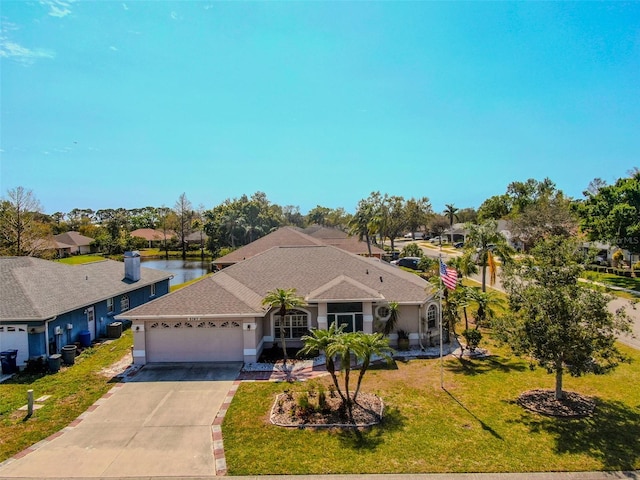 view of front of home featuring a front yard, an attached garage, driveway, and roof with shingles