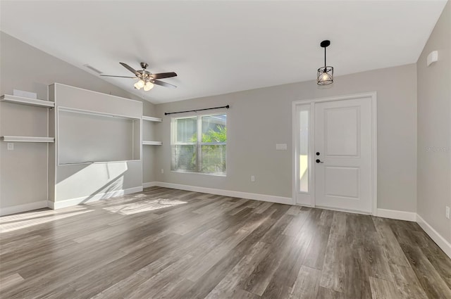 interior space featuring wood finished floors, visible vents, baseboards, lofted ceiling, and ceiling fan