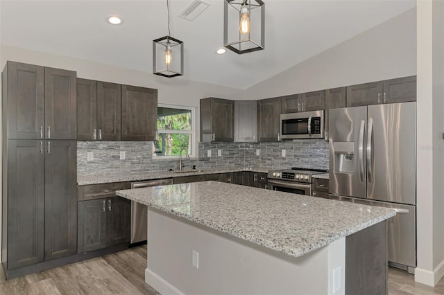 kitchen with visible vents, a sink, tasteful backsplash, appliances with stainless steel finishes, and lofted ceiling