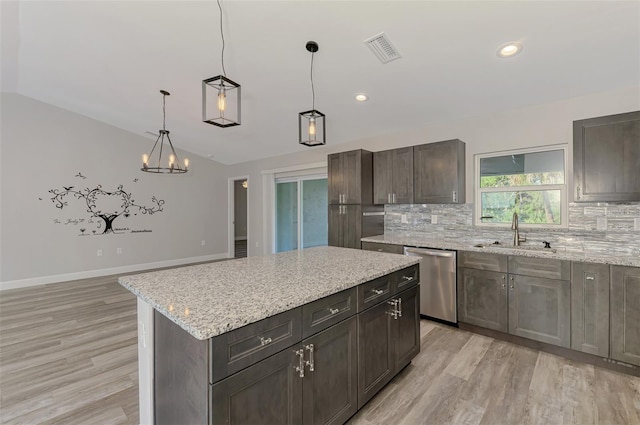 kitchen with visible vents, light wood-style flooring, a sink, dishwasher, and backsplash