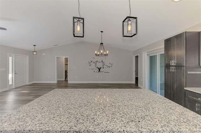 unfurnished dining area with an inviting chandelier, baseboards, lofted ceiling, and wood finished floors