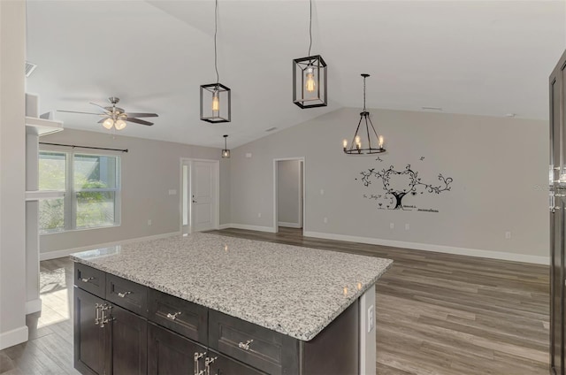 kitchen featuring light wood finished floors, baseboards, open floor plan, vaulted ceiling, and ceiling fan with notable chandelier