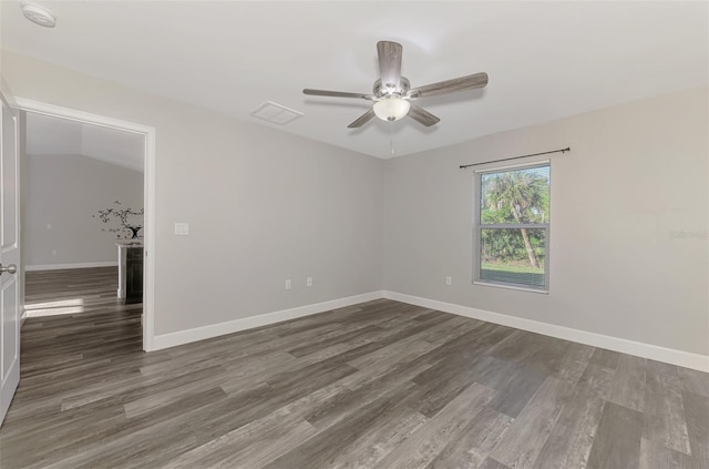 spare room with visible vents, baseboards, ceiling fan, vaulted ceiling, and wood finished floors