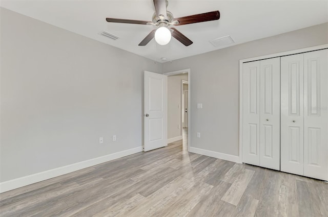 unfurnished bedroom featuring a closet, visible vents, light wood-style floors, and baseboards