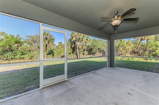 unfurnished sunroom featuring ceiling fan