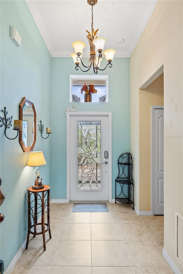 tiled foyer with visible vents, baseboards, a chandelier, and crown molding