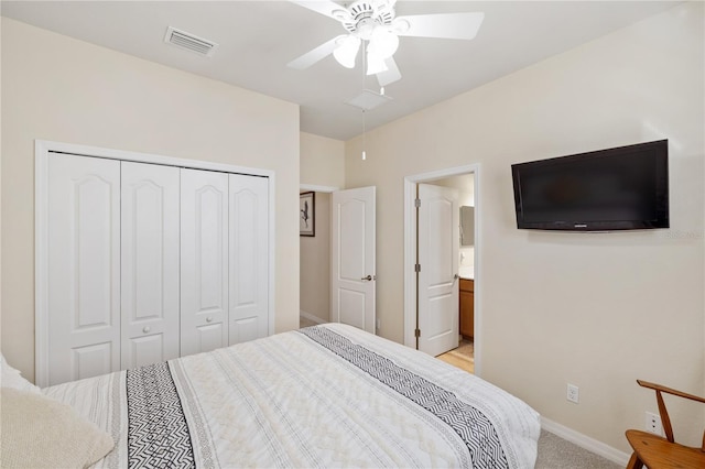 bedroom with baseboards, visible vents, ceiling fan, a closet, and light carpet