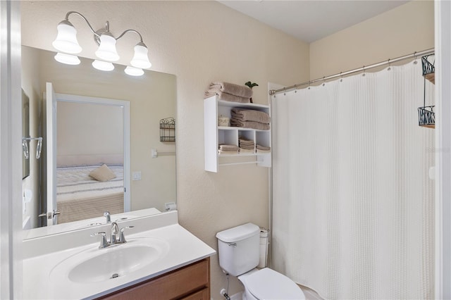 bathroom featuring toilet, vanity, and a shower with shower curtain