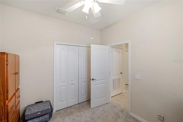 bedroom featuring a ceiling fan, visible vents, a closet, and light carpet