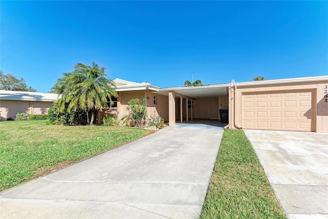 view of front of property with stucco siding, concrete driveway, a front yard, a garage, and a carport