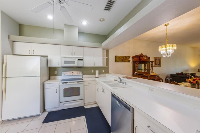 kitchen with pendant lighting, light countertops, light tile patterned floors, white appliances, and a sink