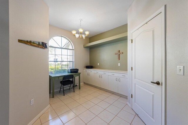 interior space with light countertops, an inviting chandelier, light tile patterned flooring, white cabinetry, and open shelves