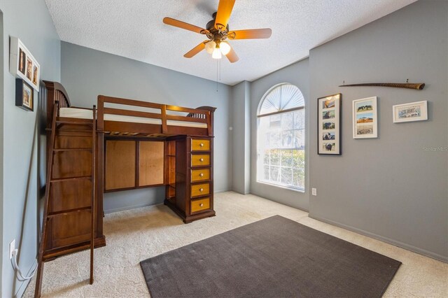 bedroom featuring a textured ceiling, ceiling fan, and carpet floors