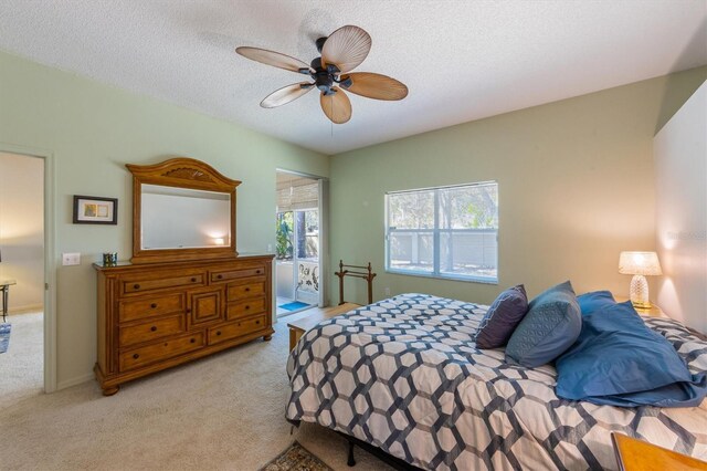 bedroom with baseboards, light colored carpet, ceiling fan, and a textured ceiling